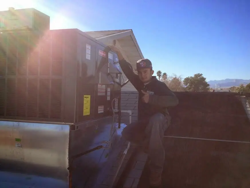 HVAC technician performing AC Tune-Up on a rooftop unit in Ranson corporation